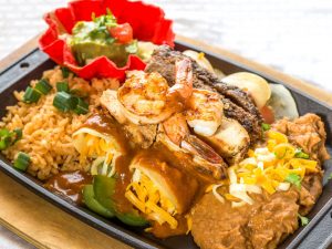 Enchilada dinner plate with refried beans and rice