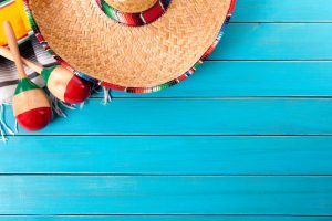 Mexican sombrero and maracas with traditional serape blanket laid on an old blue painted pine wood floor